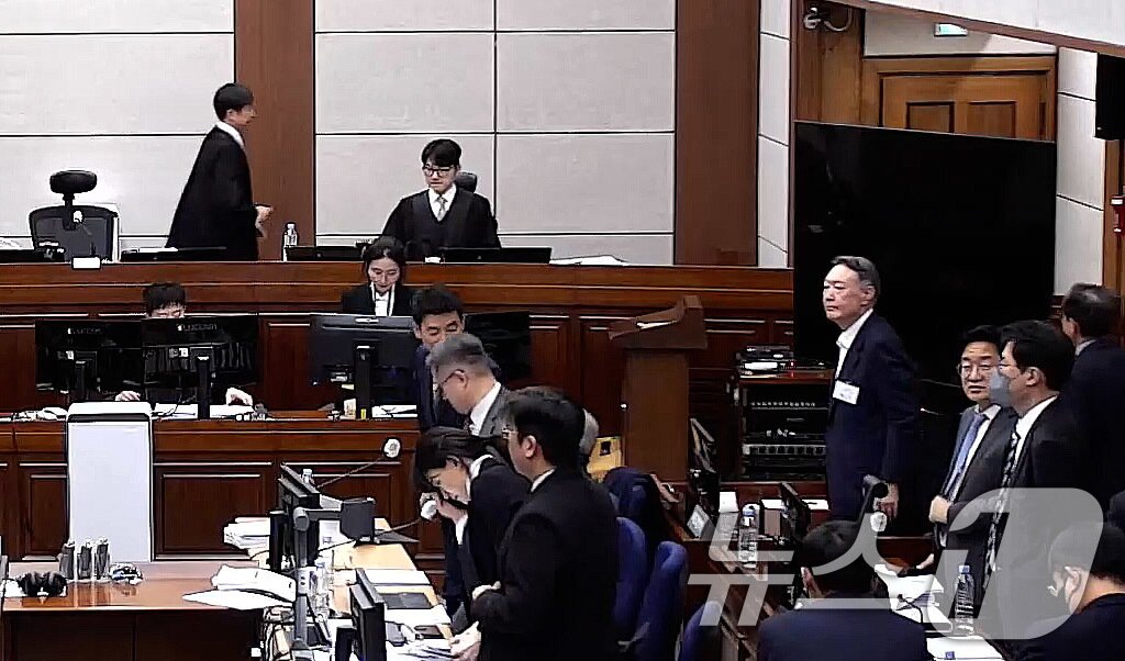 본문 이미지 - 윤석열 전 대통령이 9일 오후 서울 서초구 서울중앙지방법원에서 열린 내란 우두머리 혐의 1심 결심 공판이 휴정되자 자리에서 일어서고 있다. (서울중앙지방법원 제공 영상 캡쳐. 재판매 및 DB 금지) 2026.1.9/뉴스1