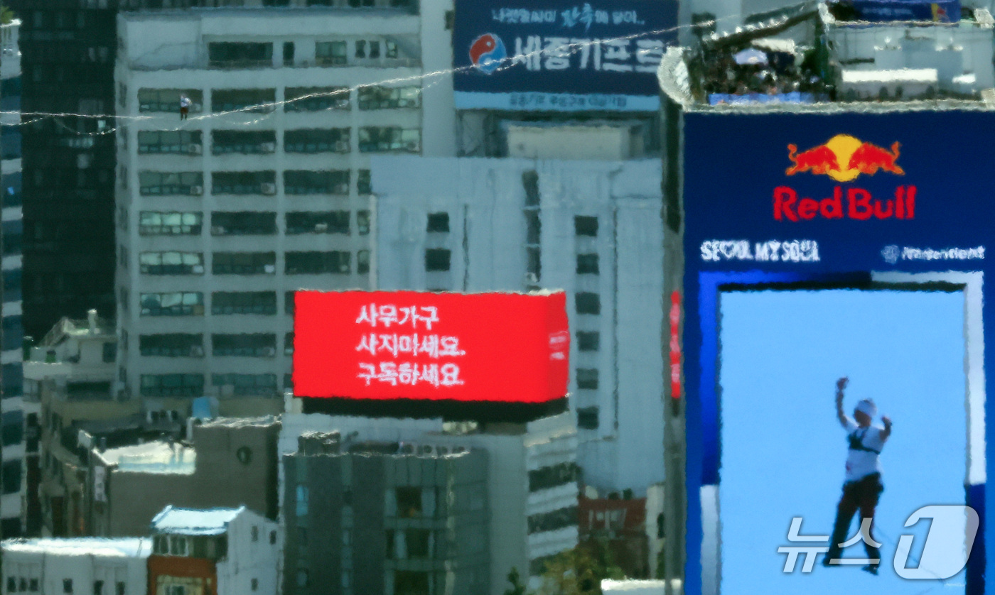 (서울=뉴스1) 김성진 기자 = 세계적인 슬랙라인 선수 얀 루스가 1일 서울 종로구 광화문네거리에서 열린 '레드불 서울 줄타기'에서 고공 줄타기를 하고 있다.슬랙라인은 두 지점 사 …