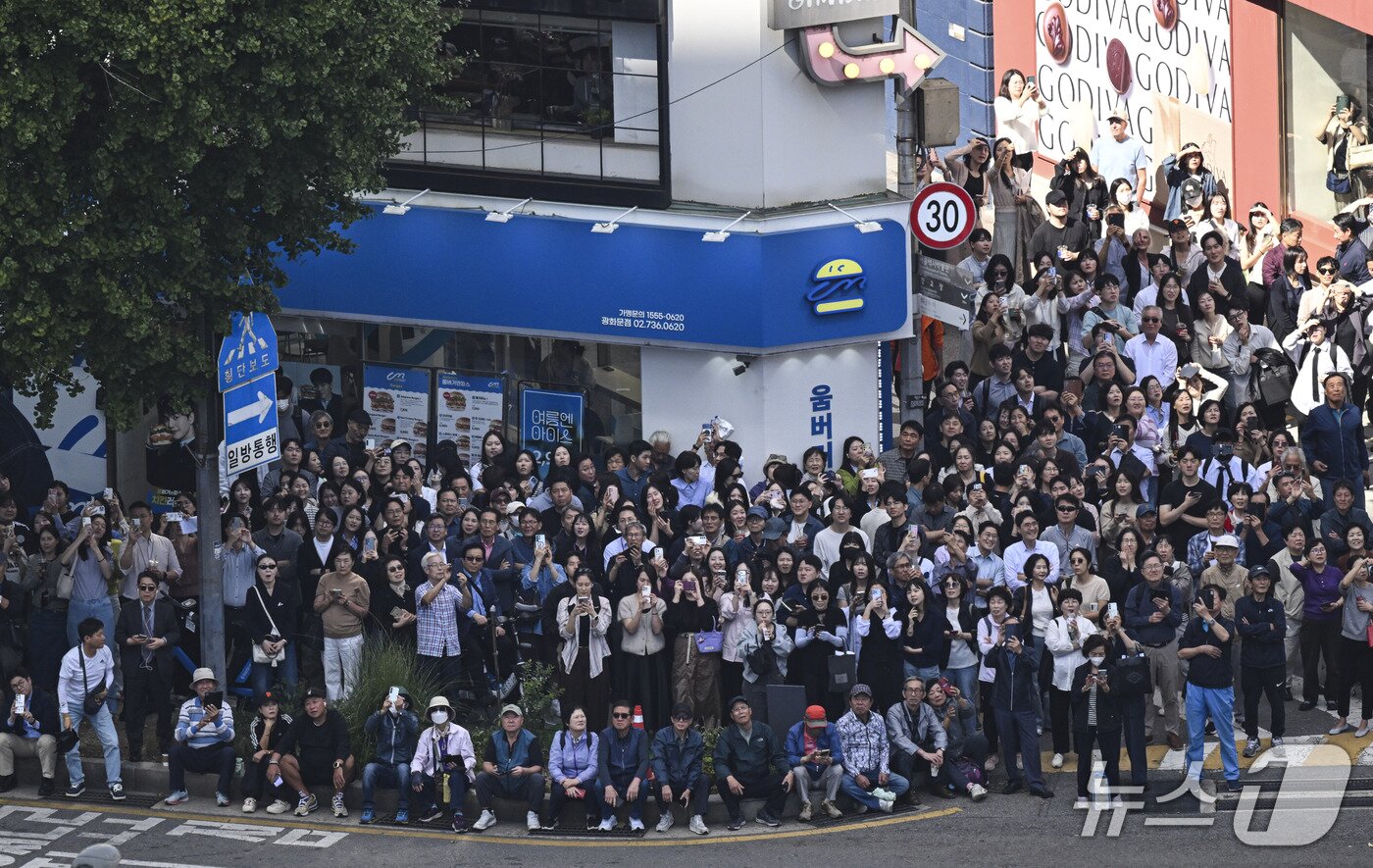 본문 이미지 - 시민들이 1일 서울 광화문 사거리 약 120m 상공에서 열린 레드불 서울 줄타기 퍼포먼스를 관람하고 있다. 2026.10.1 ⓒ 뉴스1 박세연 기자