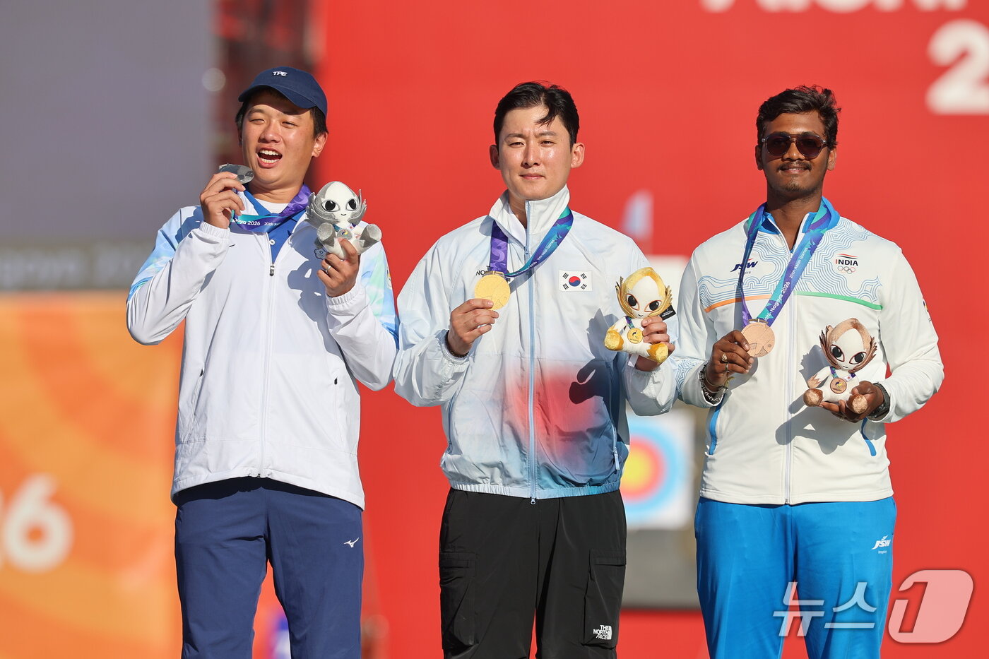 본문 이미지 - 대한민국 김종호(가운데)가 1일 일본 오카자키 중앙종합공원 다목적광장에서 열린 2026 아이치·나고야 아시안게임 양궁 컴파운드 남자 개인전 시상식에서 금메달을 목에 걸고 기뻐하고 있다. 2026.10.1 ⓒ 뉴스1 김도우 기자