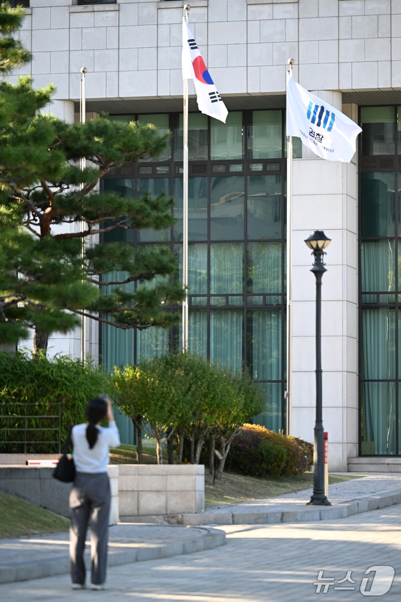 (서울=뉴스1) 최지환 기자 = 공소청 출범을 하루 앞둔 1일 서울 서초구 대검찰청 경내에서 한 여성이 검찰 깃발을 찍고 있다. (공동취재)  2026.10.1/뉴스1