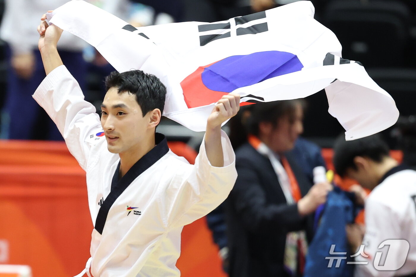 본문 이미지 - 대한민국 윤규성이 1일 일본 도요하시 체육관에서 열린 2026 아이치·나고야 아시안게임 태권도 남자 개인 품새 결승전에서 금메달을 획득한 후 태극기를 펼쳐 들며 기뻐하고 있다. 2026.10.1 ⓒ 뉴스1 안은나 기자