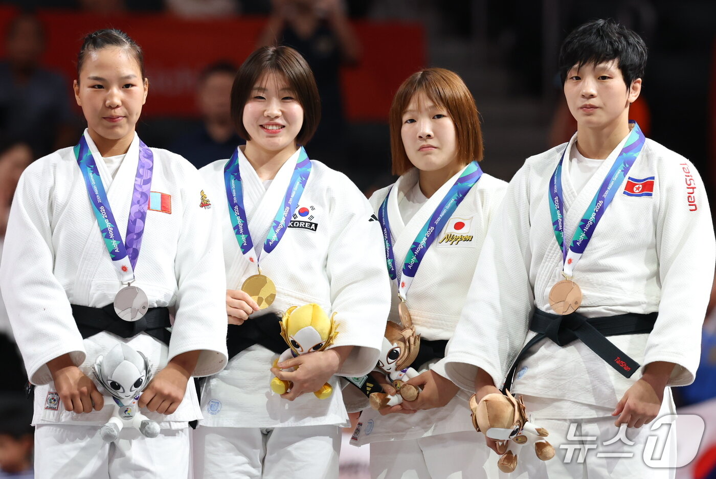 본문 이미지 - 대한민국 허미미가 1일 일본 아이치 인터내셔널 아레나에서 열린 2026 아이치·나고야 아시안게임 유도 여자 57kg급 결승 시상식에서 금메달을 들고 기뻐하고 있다. 사진 오른쪽은 동메달을 획득한 김현아. 2026.10.1 ⓒ 뉴스1 김민지 기자