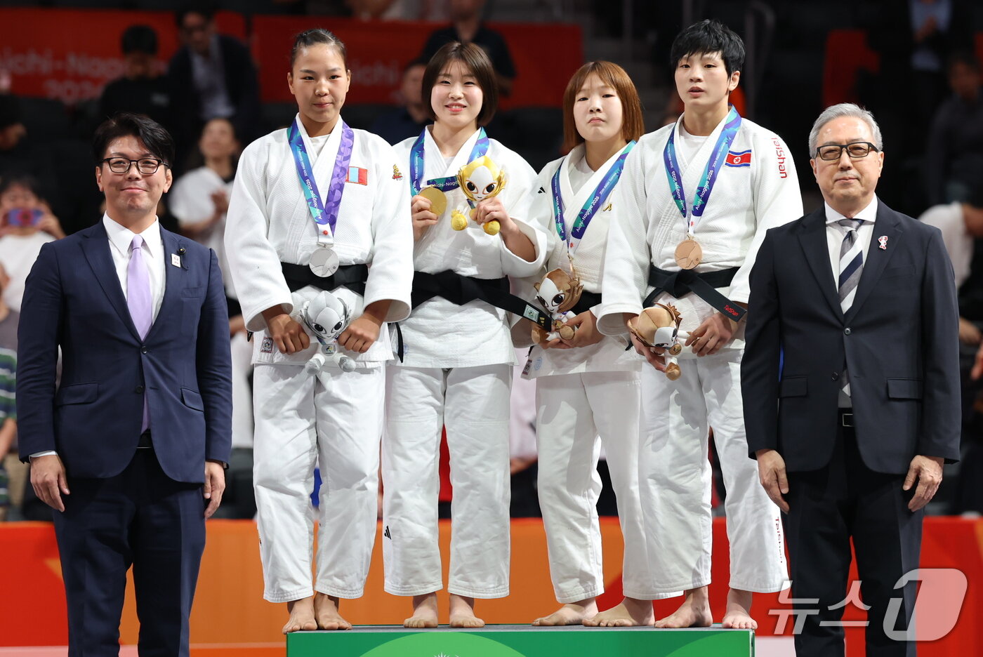 본문 이미지 - 대한민국 허미미가 1일 일본 아이치 인터내셔널 아레나에서 열린 2026 아이치·나고야 아시안게임 유도 여자 57kg급 결승 시상식에서 금메달을 들고 기뻐하고 있다. 사진 오른쪽은 동메달을 획득한 김현아. 2026.10.1 ⓒ 뉴스1 김민지 기자