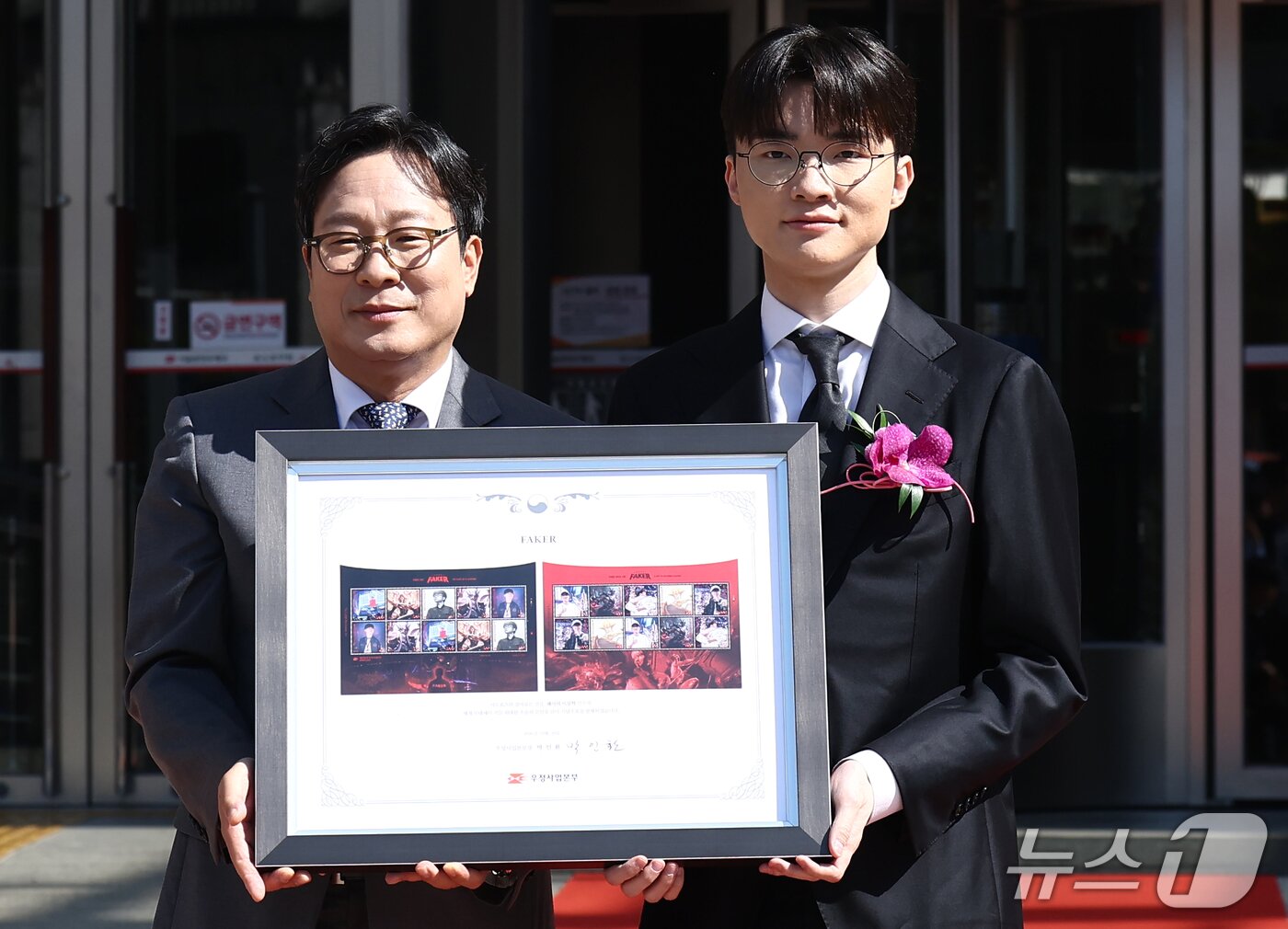 본문 이미지 - 프로게이머 '페이커' 이상혁이 10일 오후 서울중앙우체국 우표박물관에서 열린 e스포츠 전설 '페이커' 기념우표 발행 및 기획전시관 개관식에서 박인환 우정사업본부장으로부터 기념우표를 받은 뒤 기념촬영을 하고 있다. 2026.10.10 ⓒ 뉴스1 김민지 기자