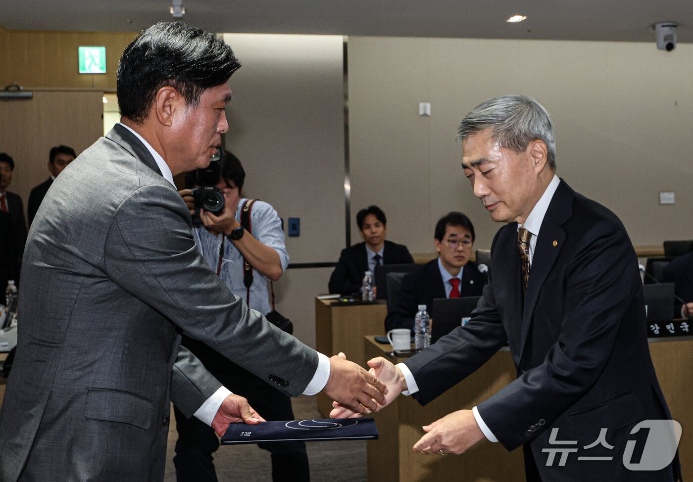 본문 이미지 - 신현송 한국은행 총재(오른쪽)가 12일 오전 서울시 중구 남대문로 한국은행에서 열린 국회 재정경제기획위원회의 한국은행 국정감사에서 조승래 위원장에게 선서문을 제출하고 있다. (공동취재) 2026.10.12 ⓒ 뉴스1 박정호 기자