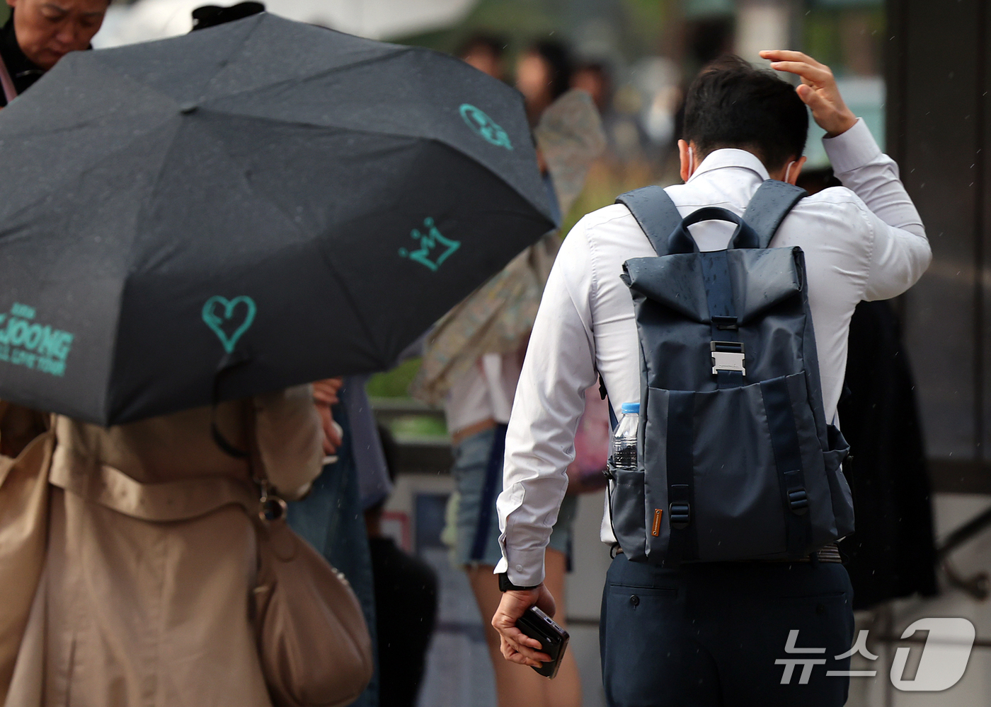 (서울=뉴스1) 김진환 기자 = 강한 소나기가 내린 12일 오후 서울 중구 롯데백화점 본점 앞에서 한 시민이 손바닥으로 비를 피하며 이동하고 있다. 2026.10.12/뉴스1