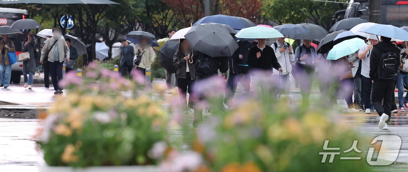 (서울=뉴스1) 이종덕 기자 = 13일 오전 우산을 쓴 시민들이 서울 광화문에서 출근길 발걸음을 재촉하고 있다. 기상청은 오후에 기온이 뚝 떨어지겠다고 예보했다.  2026.10. …