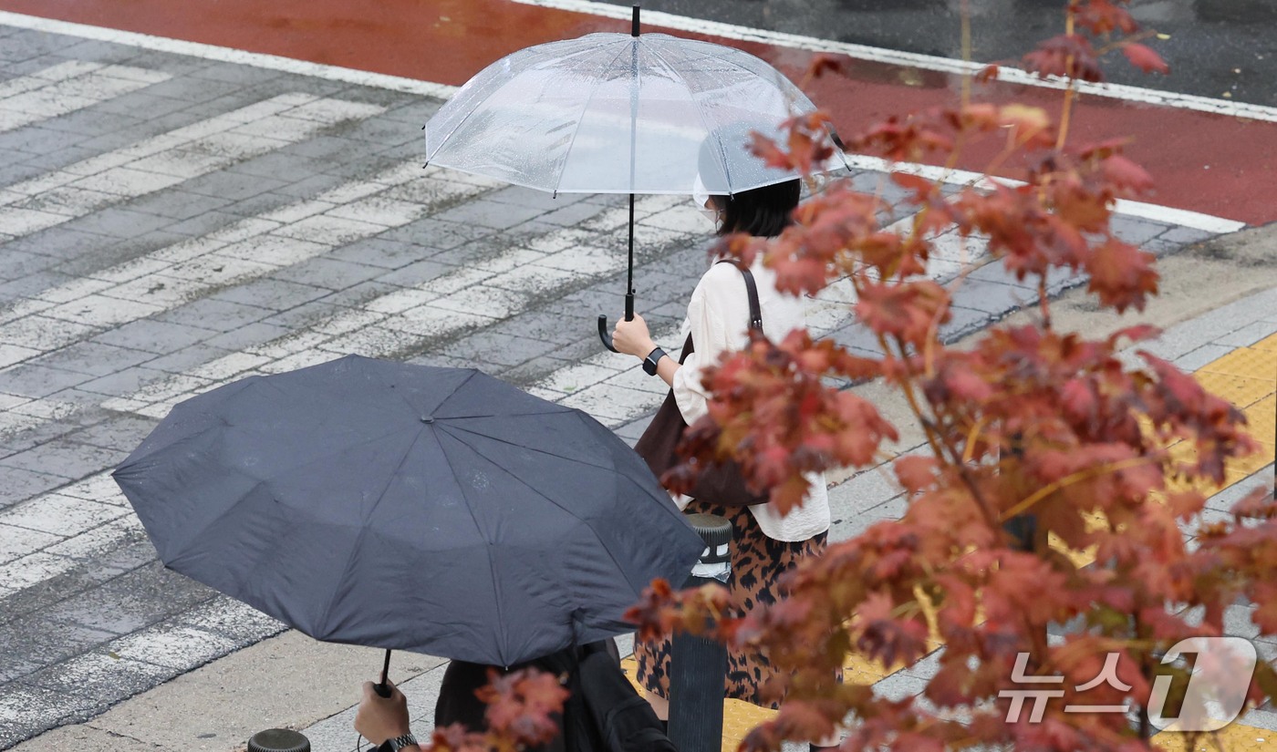 (서울=뉴스1) 이종덕 기자 = 13일 오전 우산을 쓴 시민들이 서울 태평로에서 출근길 발걸음을 재촉하고 있다. 기상청은 오후에 기온이 뚝 떨어지겠다고 예보했다.  2026.10. …