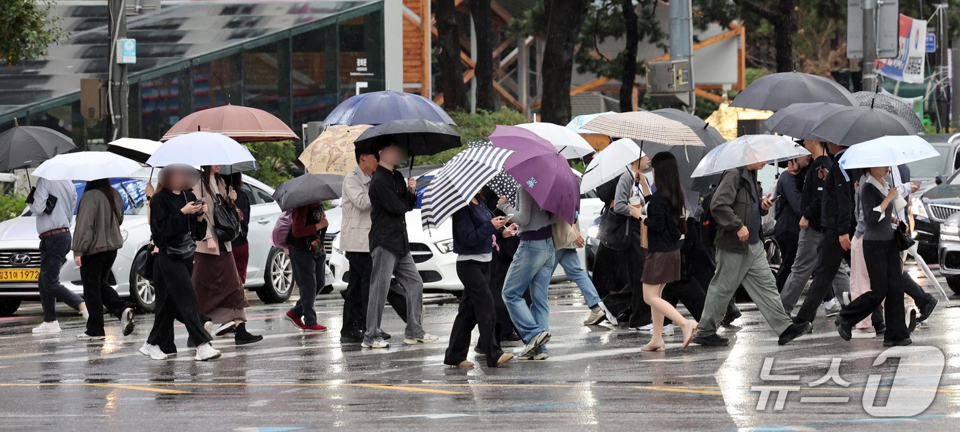 (서울=뉴스1) 이종덕 기자 = 13일 오전 우산을 쓴 시민들이 서울 광화문에서 출근길 발걸음을 재촉하고 있다. 기상청은 오후에 기온이 뚝 떨어지겠다고 예보했다.  2026.10. …