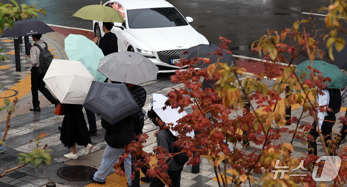 (서울=뉴스1) 이종덕 기자 = 13일 오전 우산을 쓴 시민들이 서울 광화문에서 출근길 발걸음을 재촉하고 있다. 기상청은 오후에 기온이 뚝 떨어지겠다고 예보했다. 2026.10.1 …
