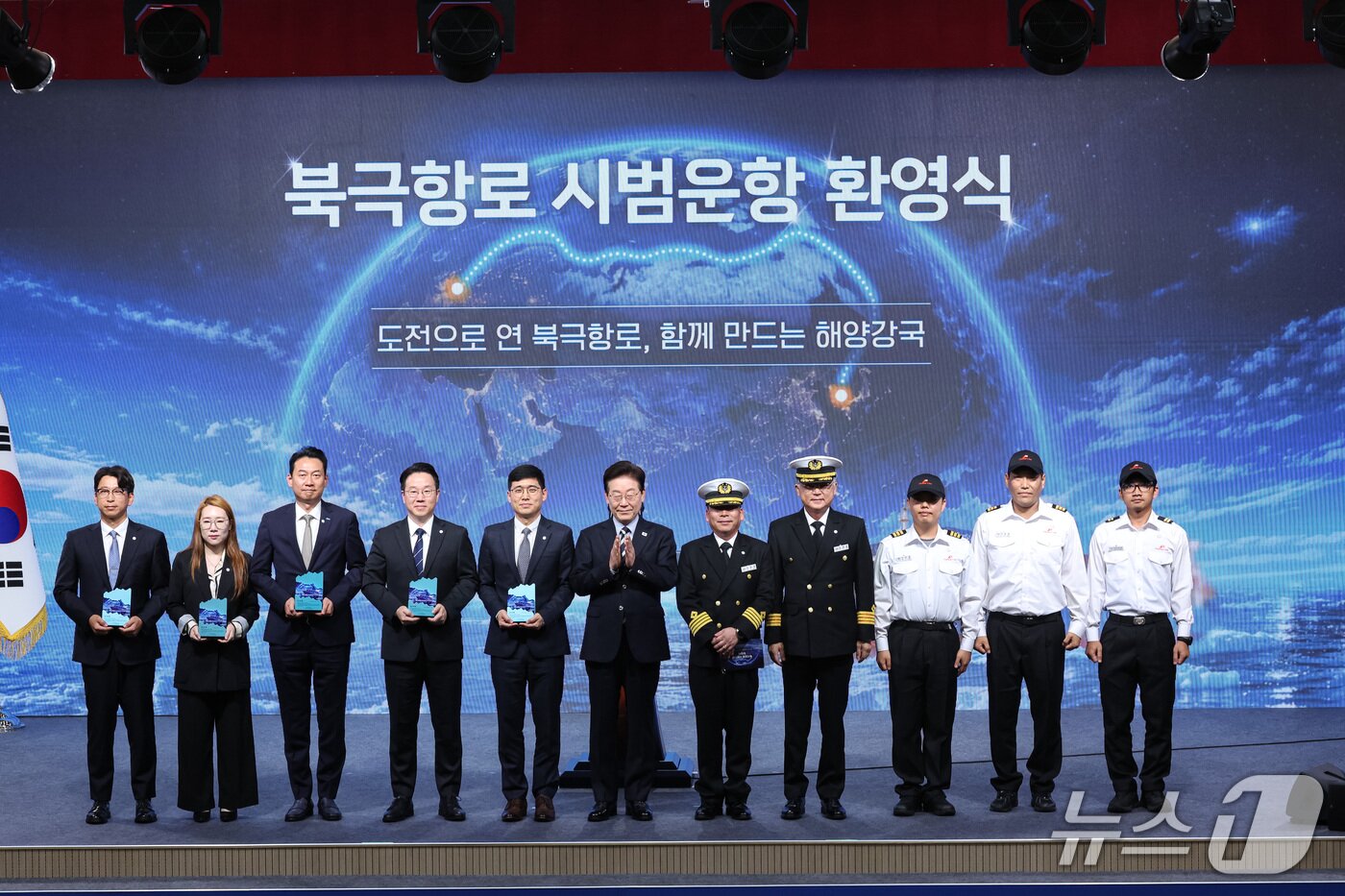 본문 이미지 - 이재명 대통령이 13일 부산에서 열린 북극항로 시범운항 환영식에서 참석자들과 기념촬영을 하고 있다. 2026.10.13 ⓒ 뉴스1 허경 기자