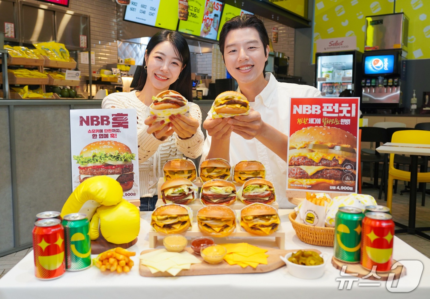 (서울=뉴스1) = 14일 서울 성동구 노브랜드 버거 성수랩점에서 모델들이 3세대 대표 메뉴 ‘NBB 훅’과 ‘NBB 펀치’를 소개하고 있다.신메뉴 2종은 패티·치즈·소스의 풍미와 …