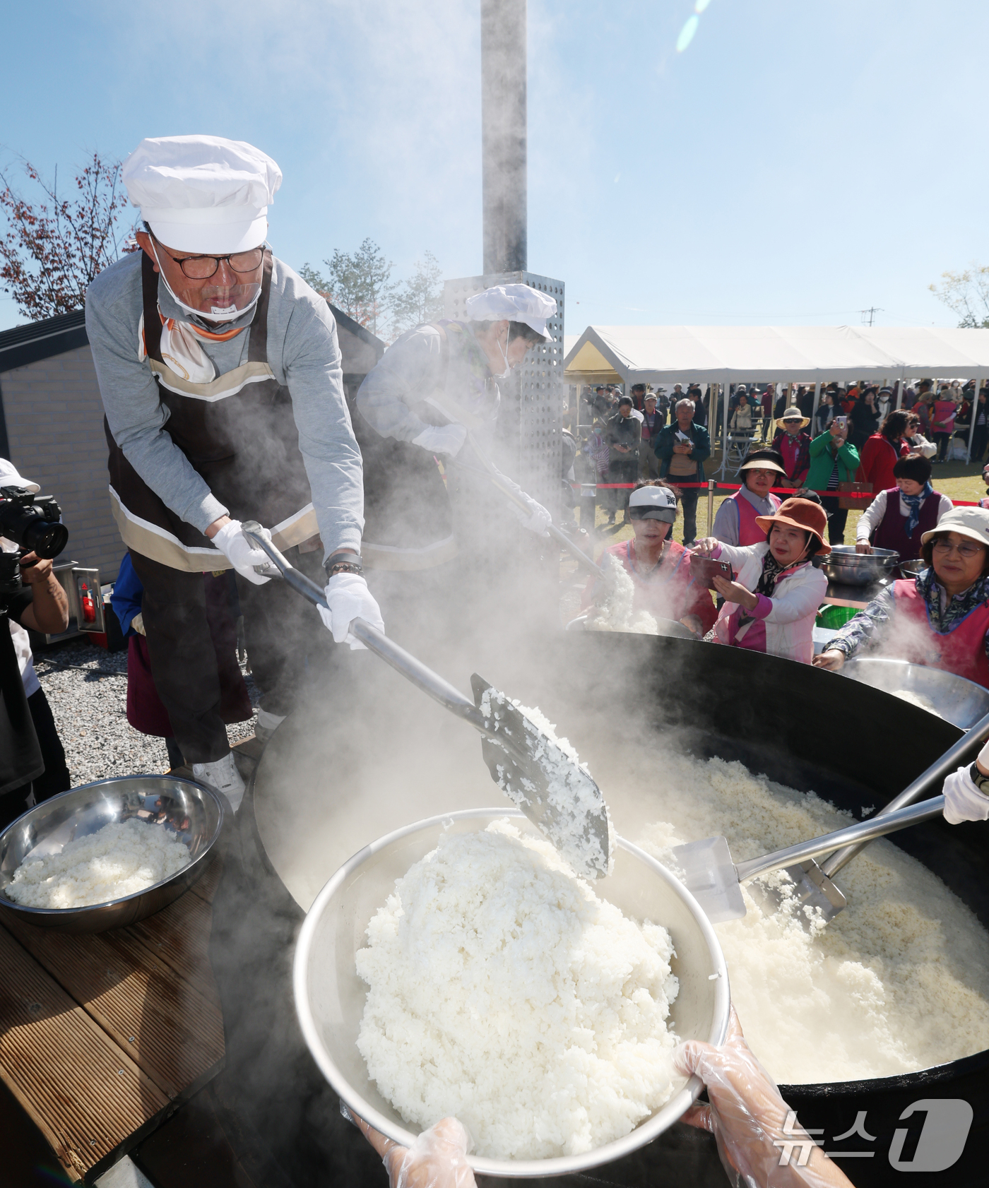 (이천=뉴스1) 김영운 기자 = ‘제25회 이천쌀문화축제’가 개막한 14일 경기 이천시 복하천 수변공원에서 행사 관계자들이 2000인분 가마솥 밥을 푸고 있다. 2026.10.14 …