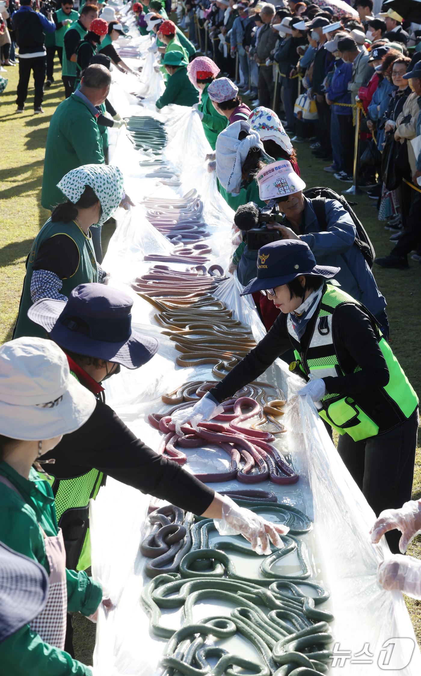 (이천=뉴스1) 김영운 기자 = ‘제25회 이천쌀문화축제’가 개막한 14일 경기 이천시 복하천 수변공원에서 행사 관계자들이 600m 가래떡을 만들고 있다. 2026.10.14/뉴스 …