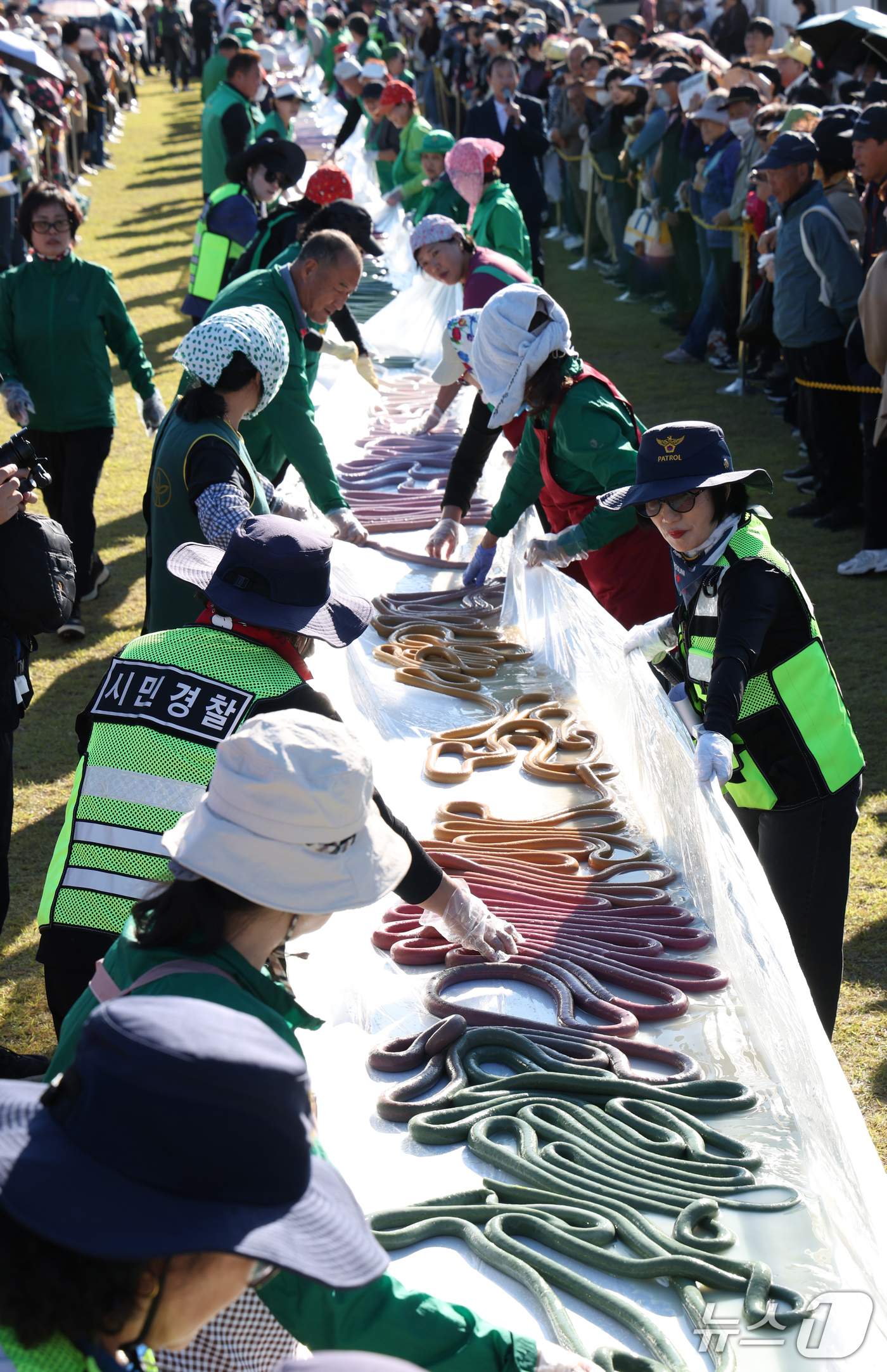 (이천=뉴스1) 김영운 기자 = ‘제25회 이천쌀문화축제’가 개막한 14일 경기 이천시 복하천 수변공원에서 행사 관계자들이 600m 가래떡을 만들고 있다. 2026.10.14/뉴스 …