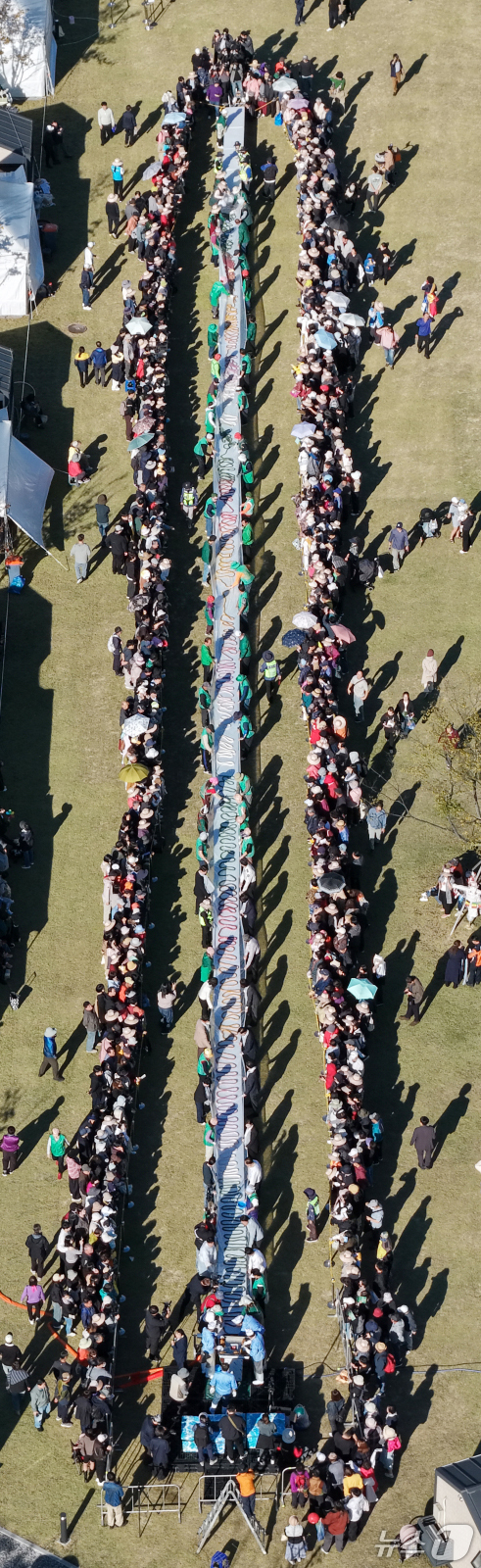 (이천=뉴스1) 김영운 기자 = ‘제25회 이천쌀문화축제’가 개막한 14일 경기 이천시 복하천 수변공원에서 행사 관계자들이 600m 가래떡을 만들고 있다. (공동취재) 2026.1 …