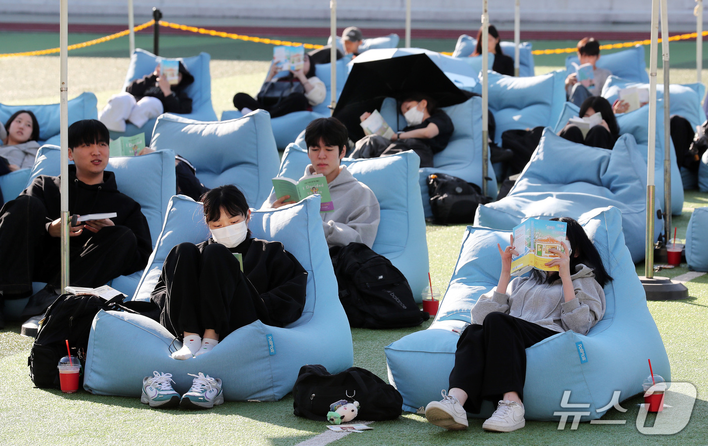 (부산=뉴스1) 윤일지 기자 = 14일 오후 부산 부산진구 동의과학대학교 인조잔디 운동장에서 열린 'Fall in Books' 야외도서관 행사에 참가한 학생들이 독서를 하고 있다. …