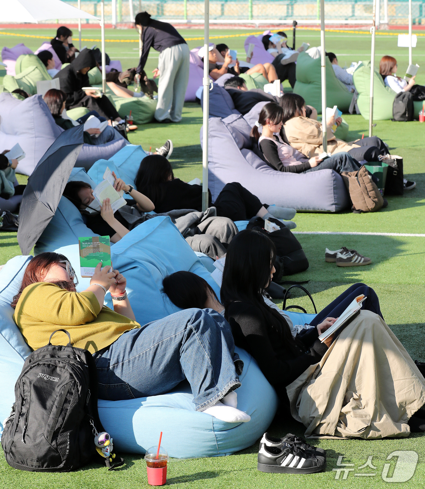 (부산=뉴스1) 윤일지 기자 = 14일 오후 부산 부산진구 동의과학대학교 인조잔디 운동장에서 열린 'Fall in Books' 야외도서관 행사에 참가한 학생들이 독서를 하고 있다. …