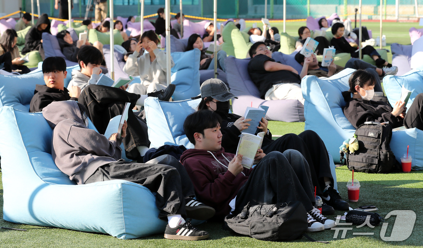 (부산=뉴스1) 윤일지 기자 = 14일 오후 부산 부산진구 동의과학대학교 인조잔디 운동장에서 열린 'Fall in Books' 야외도서관 행사에 참가한 학생들이 독서를 하고 있다. …