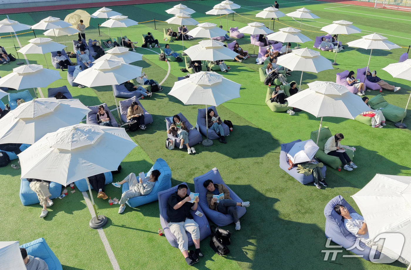 (부산=뉴스1) 윤일지 기자 = 14일 오후 부산 부산진구 동의과학대학교 인조잔디 운동장에서 열린 'Fall in Books' 야외도서관 행사에 참가한 학생들이 독서를 하고 있다. …