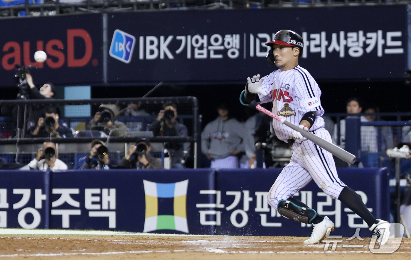 본문 이미지 - 14일 오후 서울 송파구 잠실야구장에서 열린 프로야구 '2026 신한 SOL KBO 와일드카드 결정전 1차전' 두산 베어스와 LG 트윈스의 경기, LG 신민재가 8회말 1사 1,3루 상황에서 타점을 올리는 스퀴즈 번트를 시도하고 있다. 2026.10.14 ⓒ 뉴스1 박지혜 기자