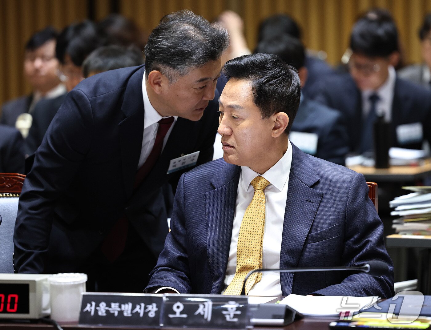 본문 이미지 - 오세훈 서울시장이 15일 서울시청에서 열린 국회 행정안전위원회의 서울시에 대한 국정감사에서 박찬구 정무부시장과 귀엣말을 나누고 있다. 2026.10.15 ⓒ 뉴스1 구윤성 기자
