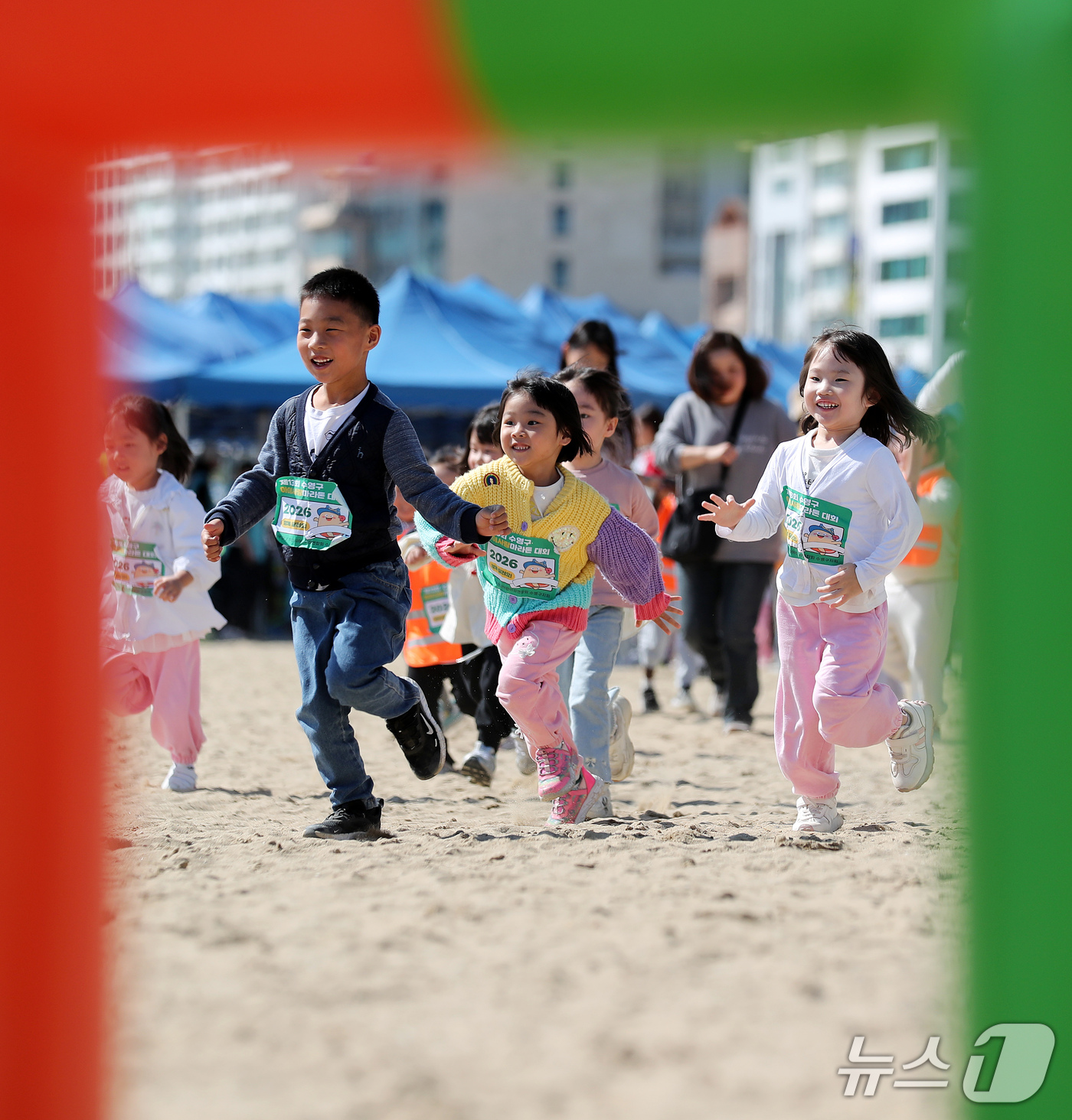 (부산=뉴스1) 윤일지 기자 = 15일 부산 수영구 광안리해수욕장에서 열린 제13회 아이사랑 마라톤 대회에 참가한 어린이들이 해맑게 웃으며 백사장을 달리고 있다.  2026.10. …
