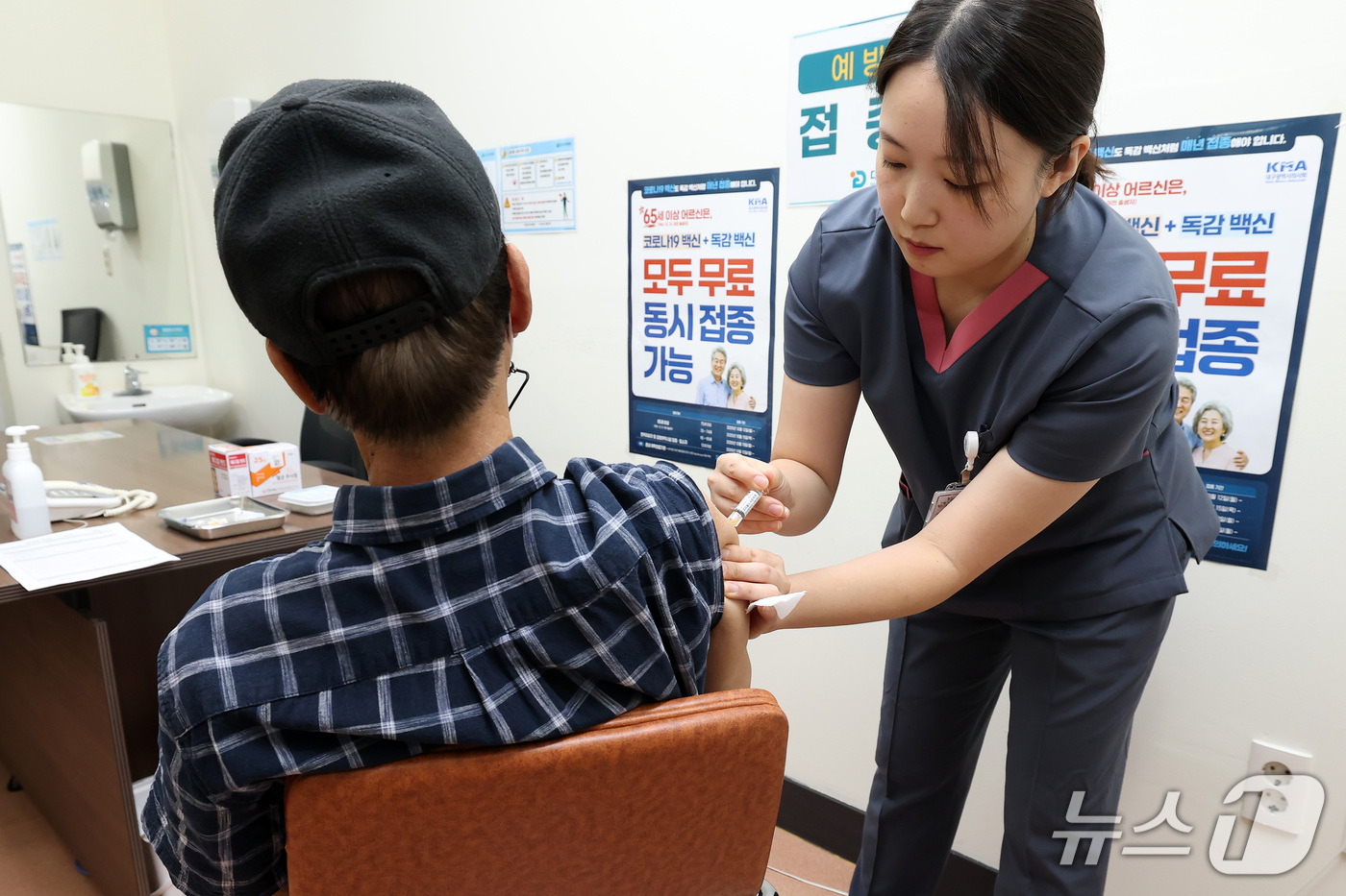 (대구=뉴스1) 공정식 기자 = 15일 대구 서구 중리동 대구의료원을 찾은 65세 이상 노인이 예방접종실에서 독감과 코로나19 동시 유행에 대비해 2가지 백신을 좌·우측 팔에 나눠 …
