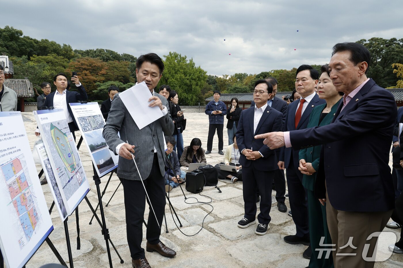 본문 이미지 - 국회 문화체육관광위원회 국민의힘 조은희 간사와 김석기, 김승수, 윤용근 의원이 15일 오후 서울시 종로구 종묘 정전에서 서울시 관계자에게 세운4구역 재정비촉진사업 개요 및 이격거리, 건축물 높이 실증 등에 대한 설명을 듣고 있다. 뒤로 보이는 파란 풍선(141미터, 142미터)과 붉은 풍선(94미터, 99미터)은 사업 대상지 높이다. 2026.10.15 ⓒ 뉴스1 박정호 기자
