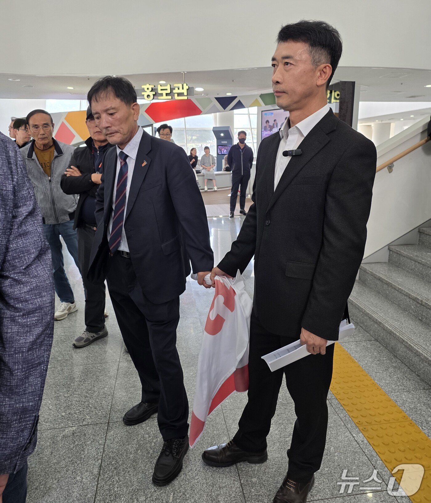 (광주=뉴스1) 서충섭 기자 = 오월단체 회원과 국민의힘 관계자가 15일 오후 전남광주통합특별시의회 광주청사 1층에서 현수막을 부여잡고 있다. 하헌식 국민의힘 서구갑 당협위원장은 …