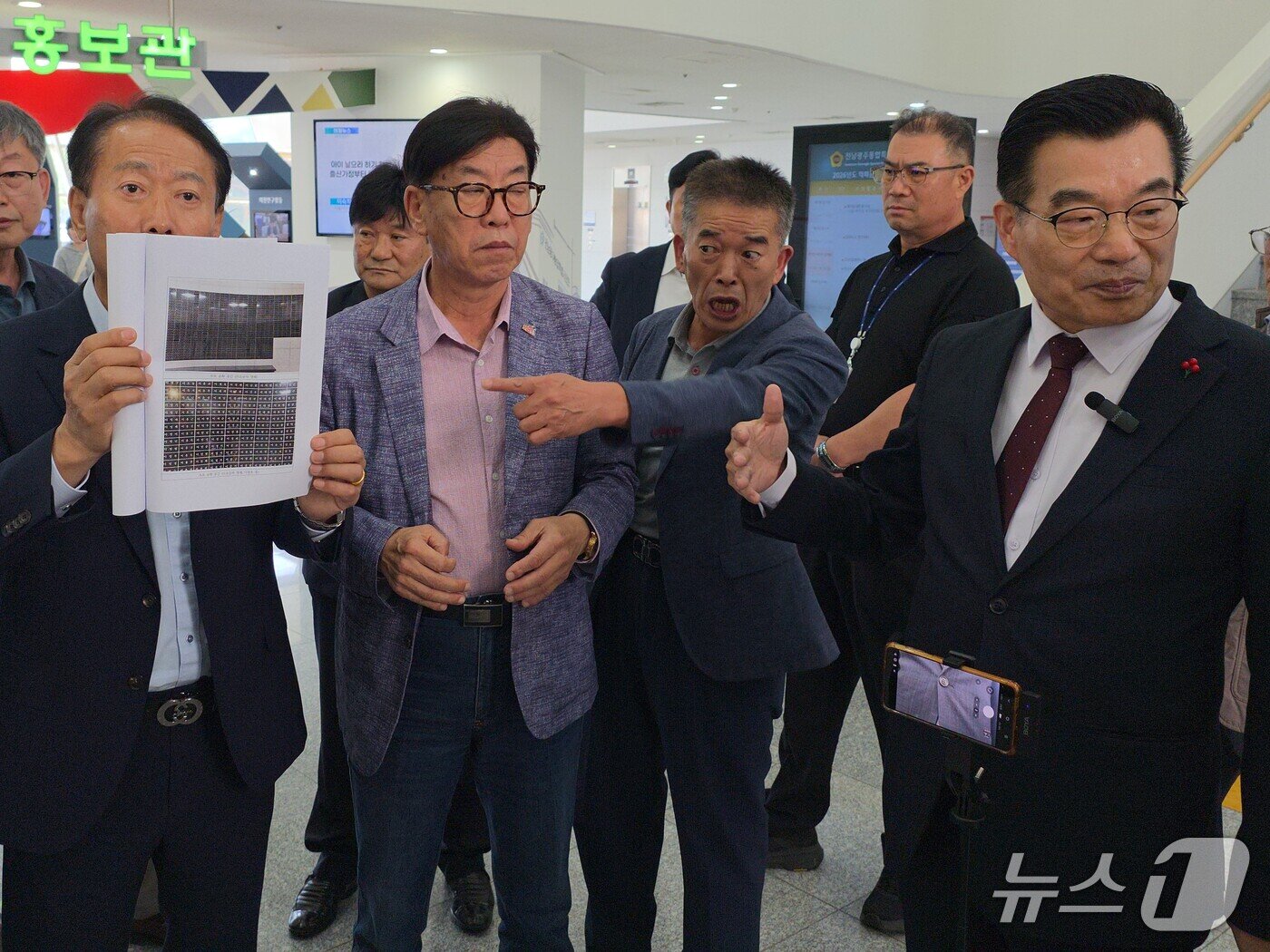 본문 이미지 - 15일 오후 전남광주통합특별시의회 광주청사 1층에서 5·18 가짜유공자 의혹 검증을 주장하려는 하헌식 국민의힘 전남광주 서구갑 당협위원장 기자회견을 저지하며 오월단체 회원이 5·18 희생자 명단이 기재된 추모공간 자료를 들어보이고 있다. ⓒ 뉴스1 서충섭 기자