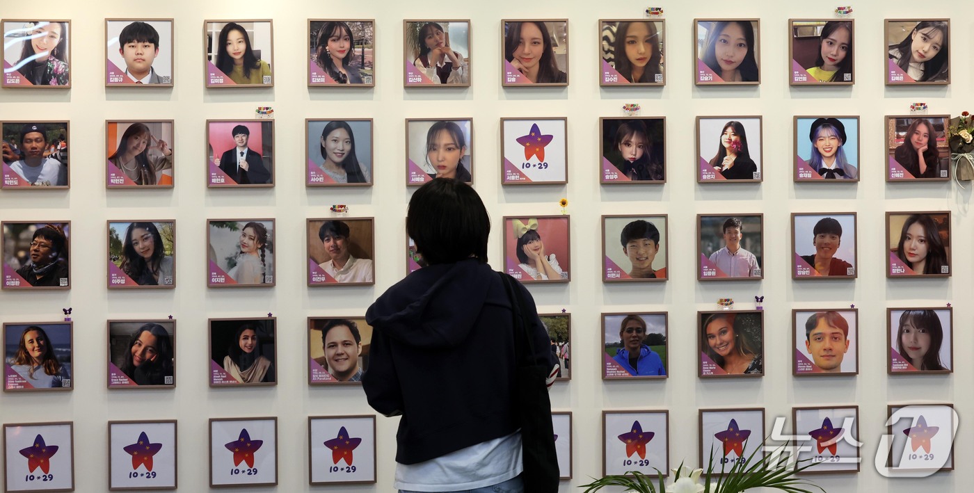 (서울=뉴스1) 이종덕 기자 = 이태원참사 4주기를 맞이하여 16일 서울 종로구 현대적선빌딩 별들의 집에서 열린 '보랏빛 나눔' 행사장을 찾은 청년이 희생자들의 사진을 보고 있다. …