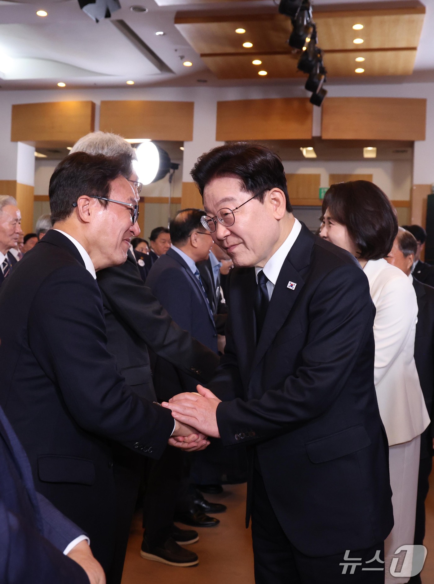 (부산=뉴스1) = 이재명 대통령이 16일 부산에서 열린 제47주년 부마민주항쟁 기념식에 입장하며 김민석 더불어민주당 대표와 인사하고 있다. (청와대통신사진기자단) 2026.10. …