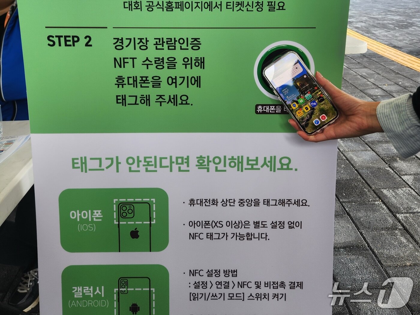 본문 이미지 - 17일 펜싱 경기를 관람하기 위한 서귀포시 종합체육관에서 휴대전화를 NFC 단말기에 태그하자 곧바로 네이버페이 월렛이 방문 인증 NFT가 추가됐다. 2026.10.17 ⓒ 뉴스1 유수연 기자