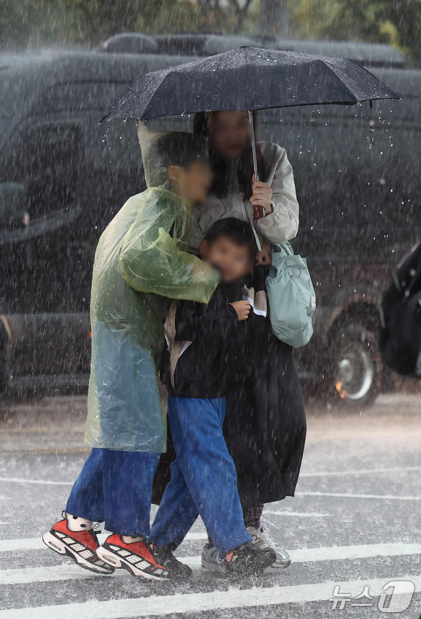 (서울=뉴스1) 김민지 기자 = 비가 내린 18일 오후 서울 종로구 경복궁 인근에서 한 가족이 우산을 쓰고 이동하고 있다. 2026.10.18/뉴스1