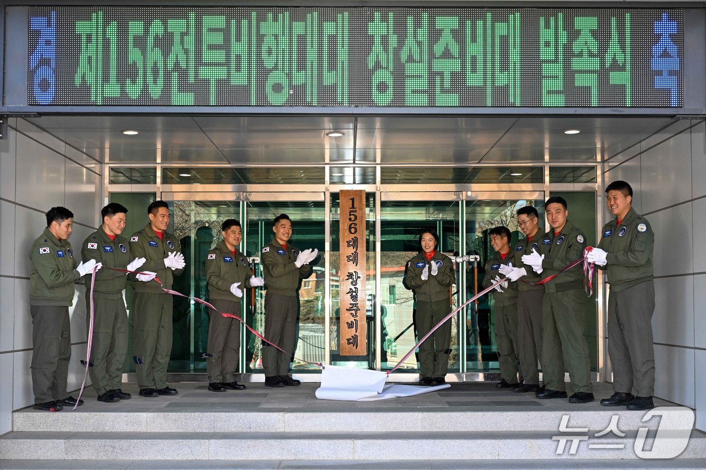본문 이미지 - 지난 1월 제156전투비행대대 창설준비대 발족식에서 배중범 중령(왼쪽에서부터 5번째) 등 조종사들이 현판 제막식을 거행 하고 있다. (공군 제공)