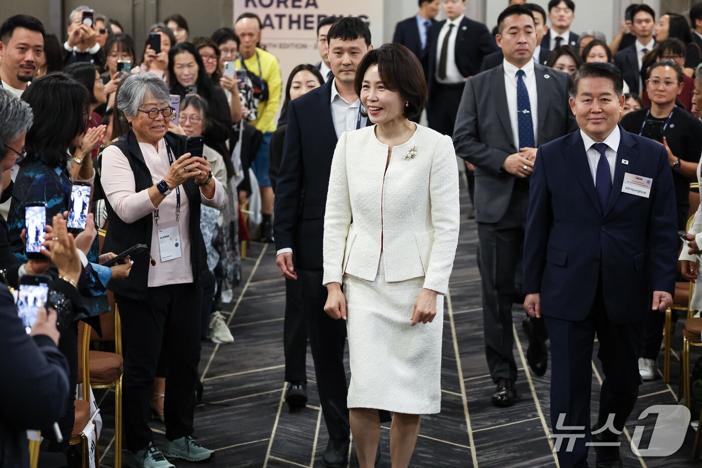 본문 이미지 - 김혜경 여사가 19일 서울 강남구 코엑스에서 열린 세계한인입양인협회(IKAA) 개더링 한국대회 개회식에 입장하고 있다. (청와대통신사진기자단) 2026.10.19 ⓒ 뉴스1 이재명 기자