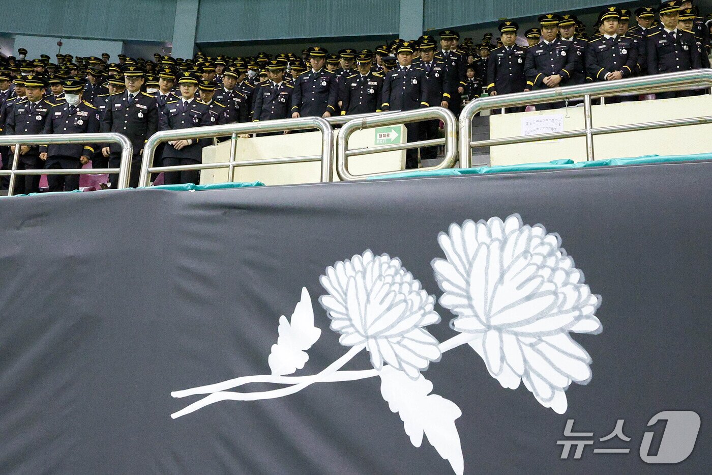 본문 이미지 - 19일 경기도 부천 원미구 부천체육관에 열린 '고(故) 김진석 소방위 영결식'에서 소방대원들이 고인을 추모하며 묵념하고 있다. 고 김 소방위는 지난 16일 부천의 한 공장에서 발생한 화재를 진압하기 위해 가장 먼저 현장에 투입된 소방대원 중 한 명이다. (공동취재) 2026.10.19 ⓒ 뉴스1 구윤성 기자