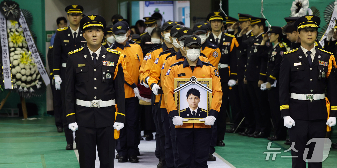 (부천=뉴스1) 구윤성 기자 = 19일 경기도 부천시 원미구 부천체육관에서 열린 고 김진석 소방위 영결식에서 고인의 운구행렬이 입장하고 있다. (공동취재) 2026.10.19/뉴스 …