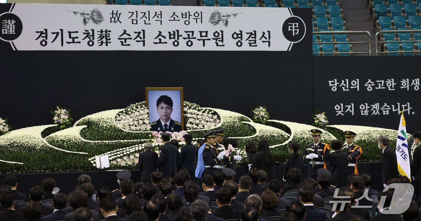 본문 이미지 - 19일 경기도 부천 원미구 부천체육관에 열린 '고(故) 김진석 소방위 영결식'에서 유족들이 헌화하고 있다. (공동취재) 2026.10.19 ⓒ 뉴스1 구윤성 기자