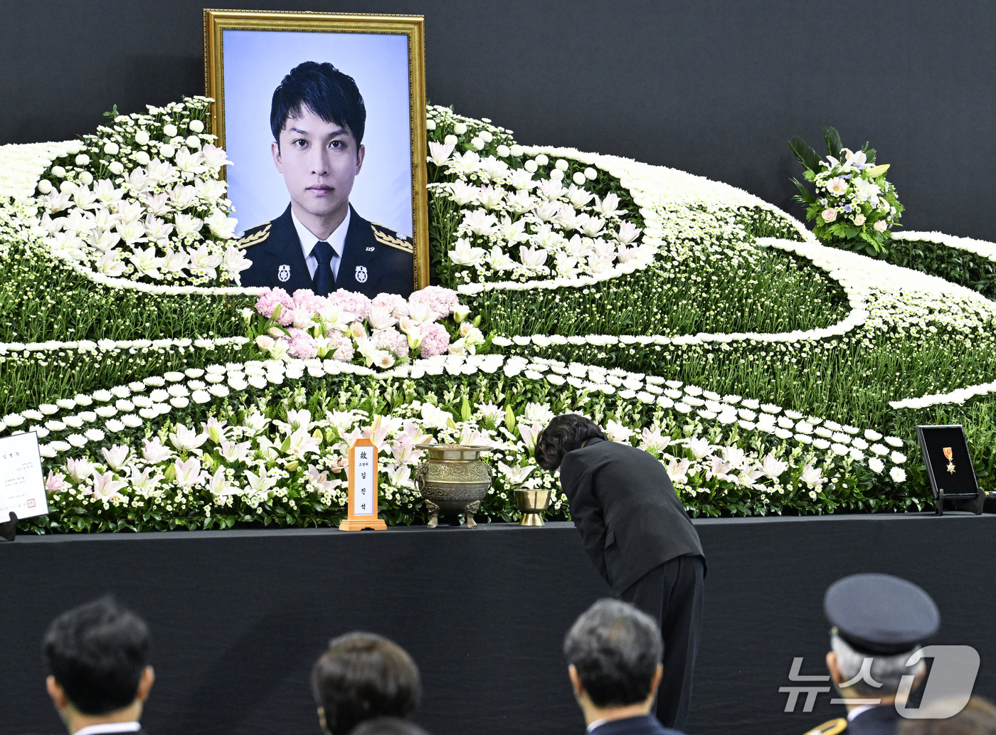 (부천=뉴스1) 구윤성 기자 = 추미애 경기도지사가 19일 경기도 부천시 원미구 부천실내체육관에서 열린 '고(故) 김진석 소방위 영결식'에서 헌화를 마친 뒤 묵념하고 있다. (공동 …