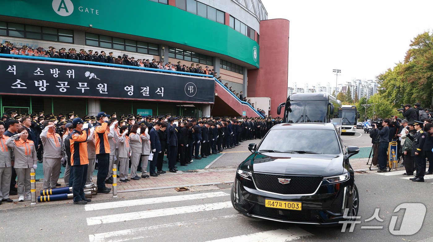 (부천=뉴스1) 구윤성 기자 = 부천 공장 화재 진압 과정에서 순직한 김진석 소방위의 영결식이 엄수된 19일 경기도 부천시 원미구 부천체육관에서 동료 소방관 등이 운구차량을 향해 …