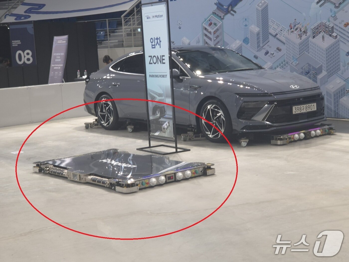 본문 이미지 - 현대위아가 2026 강릉 ITS 세계총회 전시부스에서 선보인 주차로봇(빨간 원). 주차로봇은 납작한 판 형태로 2대가 한쌍이다. 2026.10.20/뉴스1 윤왕근 기자