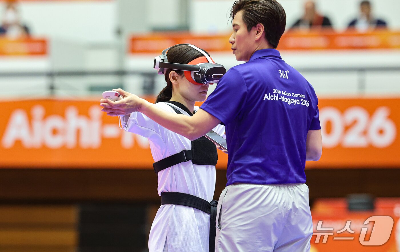 본문 이미지 - 2일 일본 도요하시 체육관에서 열린 2026 아이치·나고야 아시안게임 버추얼 태권도 16강 일본 나카지마 미호가 장비를 점검받고 있다. 2026.10.2 ⓒ 뉴스1 김도우 기자