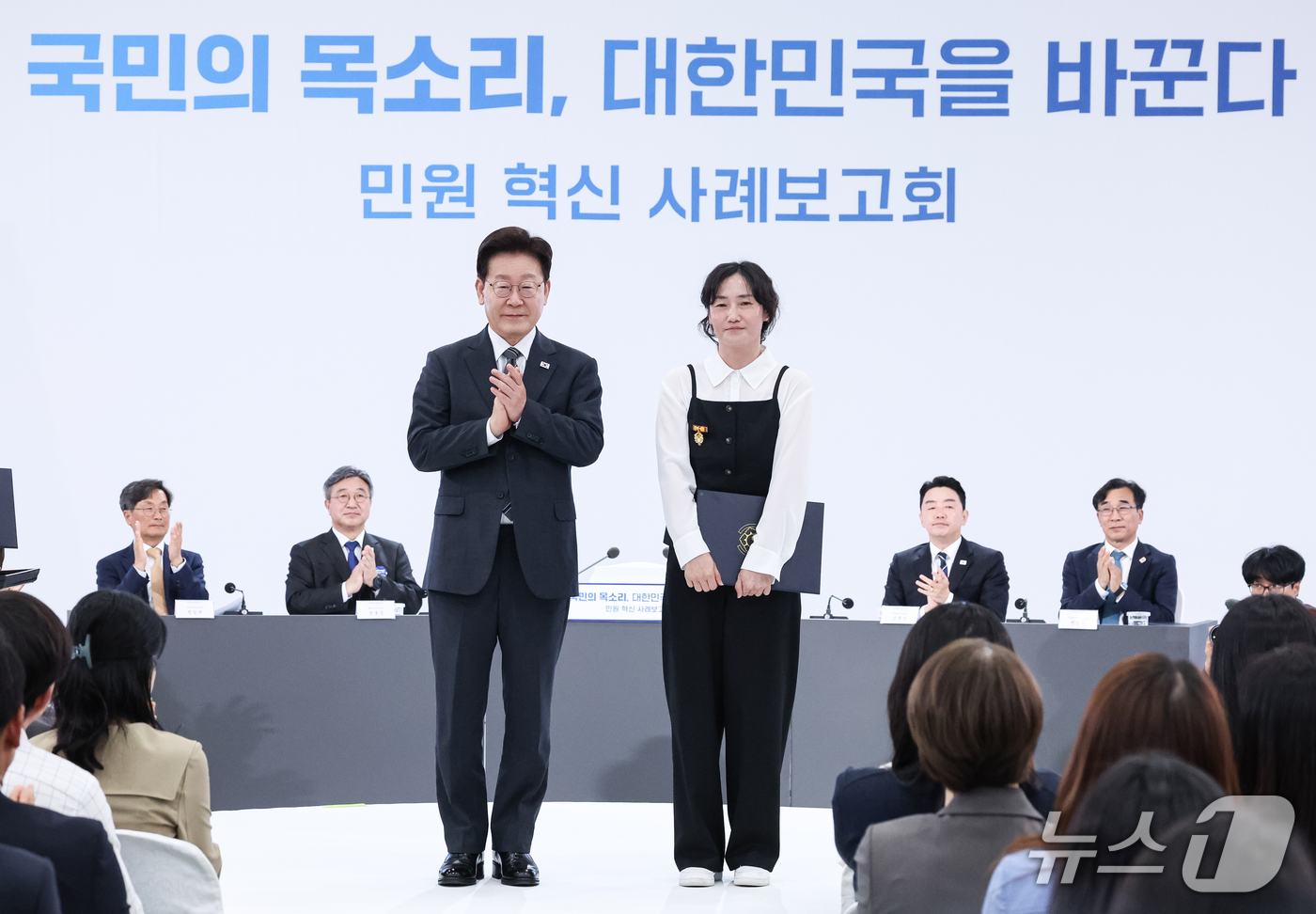 (세종=뉴스1) 이재명 기자 = 이재명 대통령이 2일 세종에서 열린 민원 혁신 사례보고회에서 정혜은 경남 창녕군 지방사회복지주사보에게 표창을 수여한 후 기념촬영을 하고 있다. (청 …