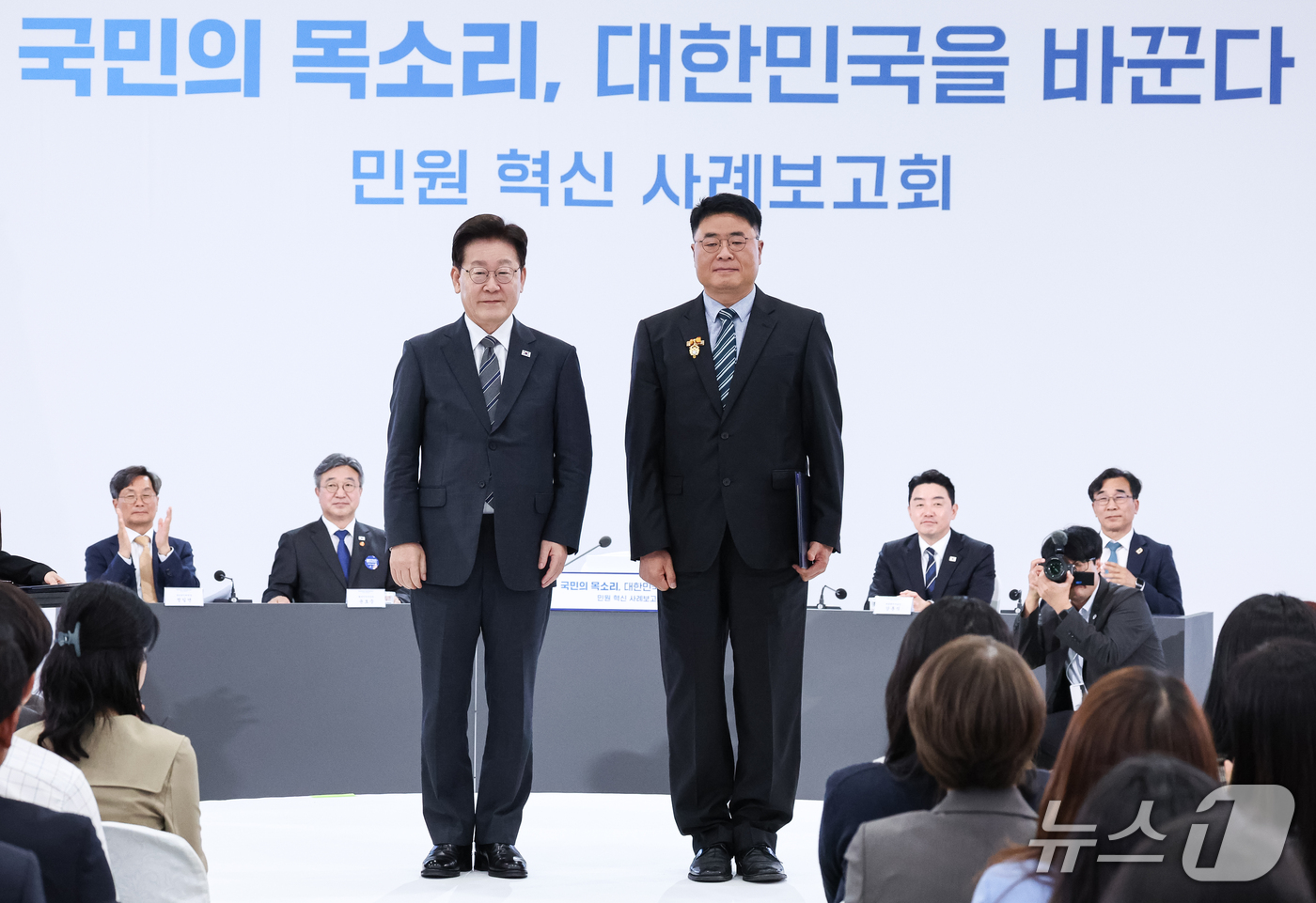 (세종=뉴스1) 이재명 기자 = 이재명 대통령이 2일 세종에서 열린 민원 혁신 사례보고회에서 경기 화성시 지방시설주사에게 표창을 수여한 후 기념촬영을 하고 있다. (청와대통신사진기 …