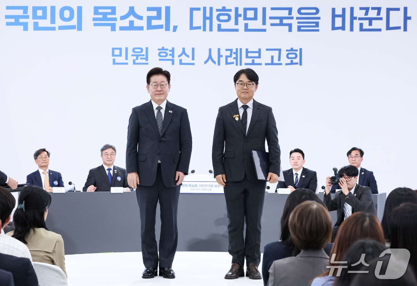 (세종=뉴스1) 이재명 기자 = 이재명 대통령이 2일 세종에서 열린 민원 혁신 사례보고회에서 경북 구미시 지방시설주사에게 표창을 수여한 후 기념촬영을 하고 있다. (청와대통신사진기 …