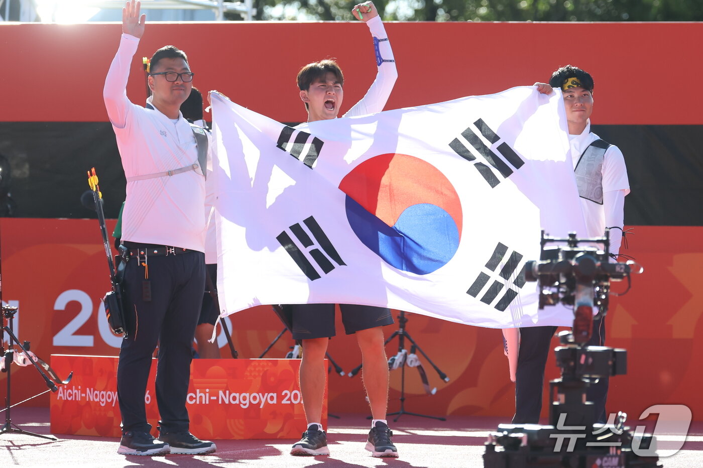 본문 이미지 - 대한민국 김우진 이우석 김제덕이 2일 일본 오카자키 중앙종합공원 다목적광장에서 열린 2026 아이치·나고야 아시안게임 양궁 리커브 남자 단체전 결승 대한민국과 인도의 경기에서 금메달을 확정 지은 후 태극기를 들고 기뻐하고 있다. 2026.10.2 2026.10.2 ⓒ 뉴스1 김민지 기자
