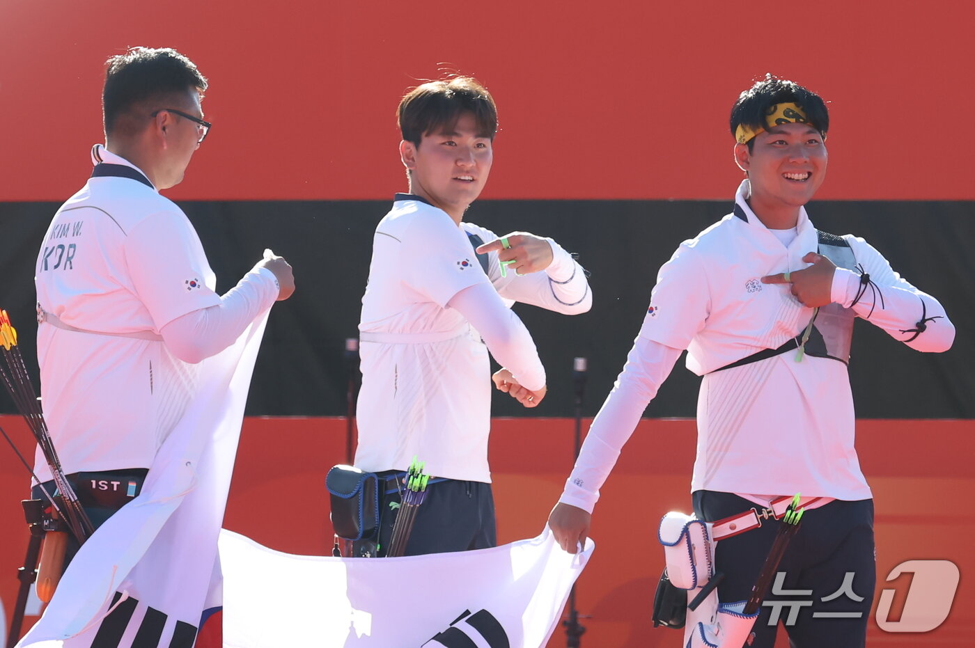 본문 이미지 - 대한민국 김우진 이우석 김제덕이 2일 일본 오카자키 중앙종합공원 다목적광장에서 열린 2026 아이치·나고야 아시안게임 양궁 리커브 남자 단체전 결승 대한민국과 인도의 경기에서 금메달을 확정 지은 후 태극기를 들고 기뻐하고 있다. 2026.10.2 ⓒ 뉴스1 김민지 기자
